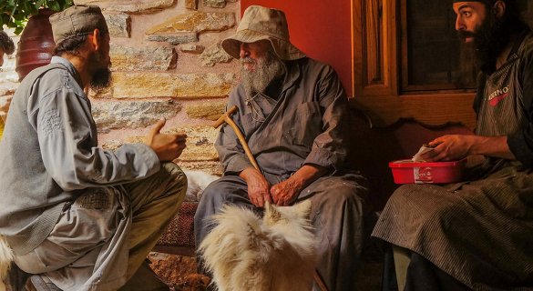Τρεις μοναχοί κάθονται και μιλούν στο Άγιον Όρος.