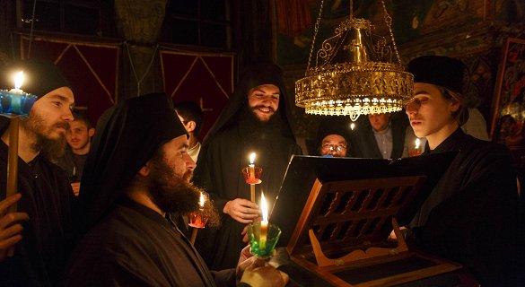 Μοναχοί στο Άγιον Όρος ψάλλουν υπό τ φως των κεριών.